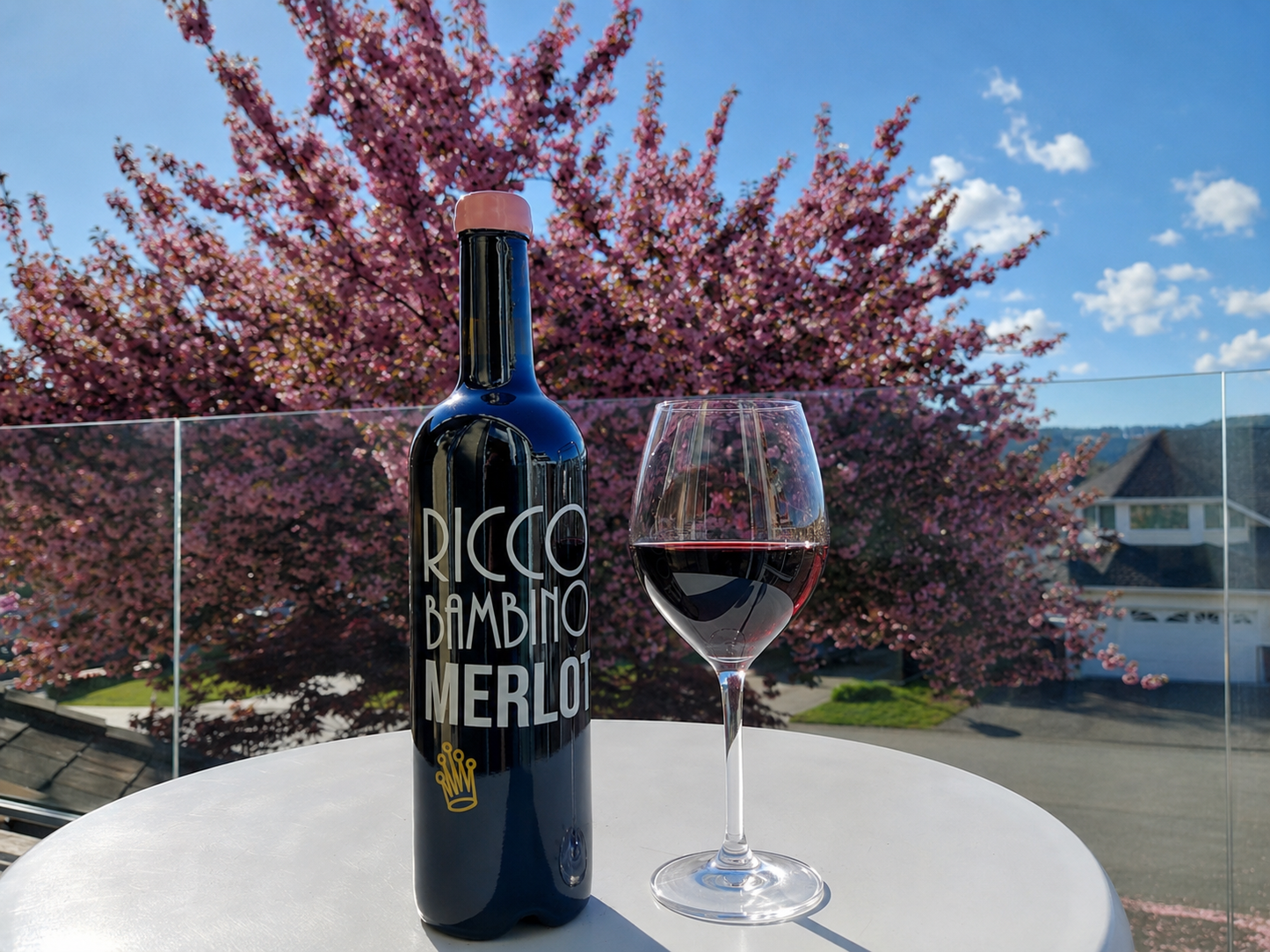 벚꽃이 만개한 봄 풍경 속 테라스에서 즐기는 Ricco Bambino Merlot 캐나다 레드 와인